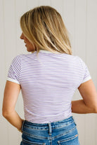 Person wearing a striped shirt and blue jeans against a plain background