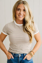 Woman wearing a striped shirt and jeans with a neutral background