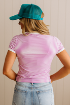 Person wearing a striped shirt and cap with a neutral background