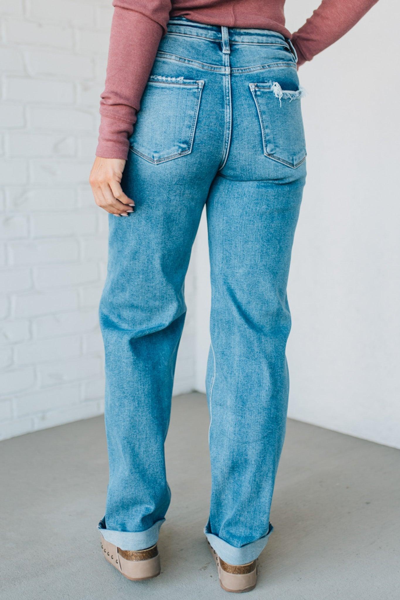Person wearing blue jeans with a plain background
