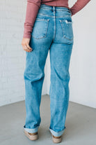 Person wearing blue jeans with a plain background
