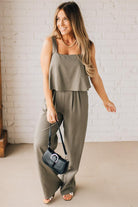 Woman holding a small black handbag with large silver buckle accent and silver hardware