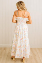 Woman wearing a floral dress with a white wooden background