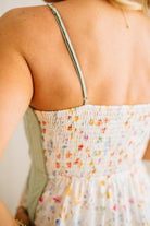 Close-up of a person wearing a colorful dress with thin straps.