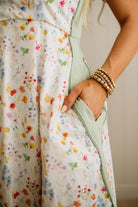 Person wearing a floral dress with a neutral background