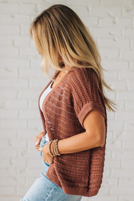 BLONDE WOMAN WEARING A CROCHET KNIT CAP SLEEVE OPEN CARDIGAN.