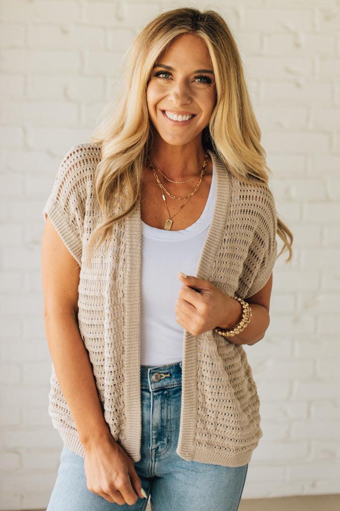 BLONDE WOMAN WEARING A CROCHET KNIT CAP SLEEVE OPEN CARDIGAN.