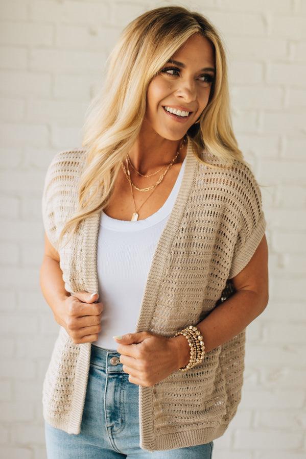 BLONDE WOMAN WEARING A CROCHET KNIT CAP SLEEVE OPEN CARDIGAN.