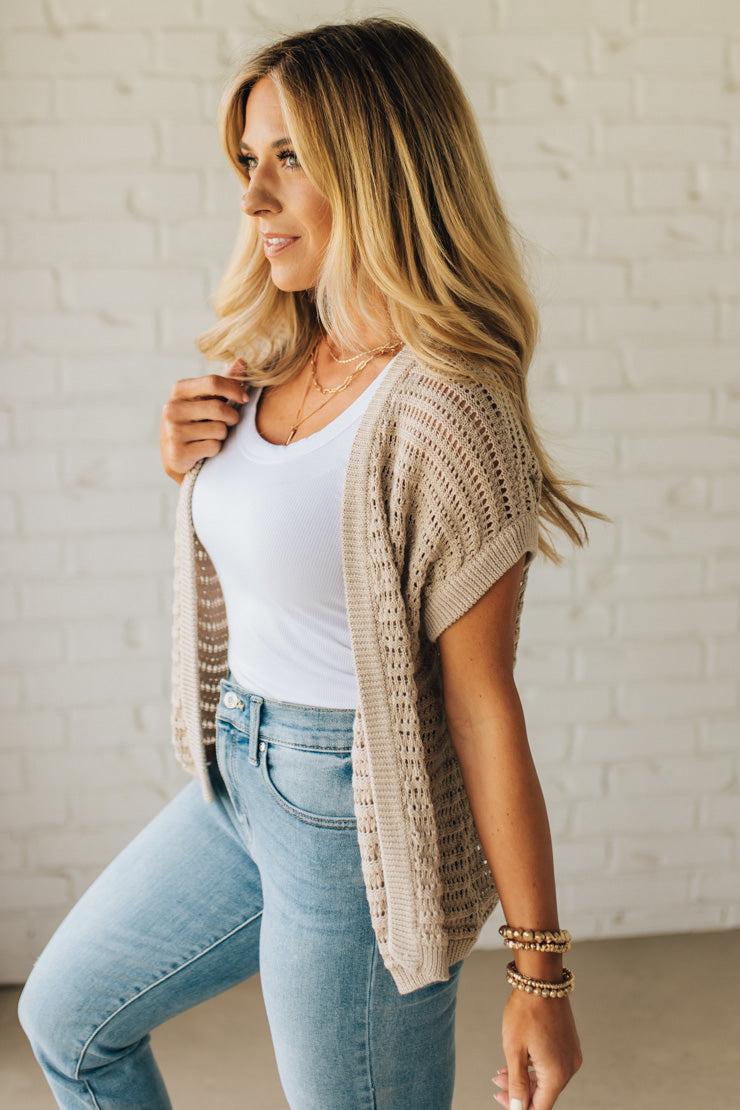 BLONDE WOMAN WEARING A CROCHET KNIT CAP SLEEVE OPEN CARDIGAN.