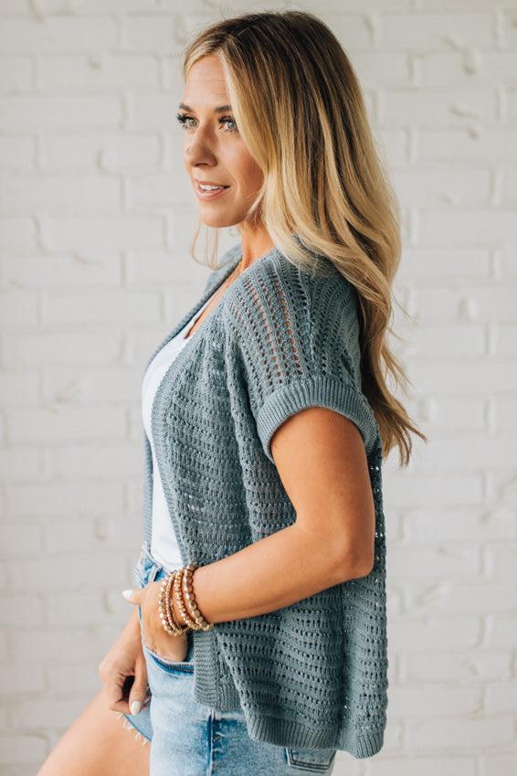 BLONDE WOMAN WEARING A CROCHET KNIT CAP SLEEVE OPEN CARDIGAN.
