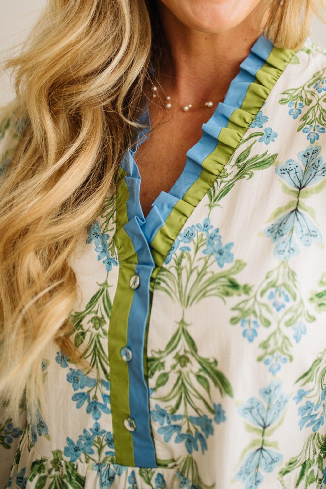 Close-up of a woman wearing a floral dress with blue and green accents.