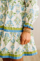Close-up of a person wearing a floral dress with green and blue accents.