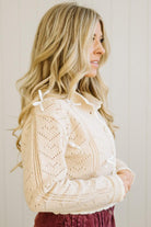 Woman wearing a beige knitted cardigan with a white background
