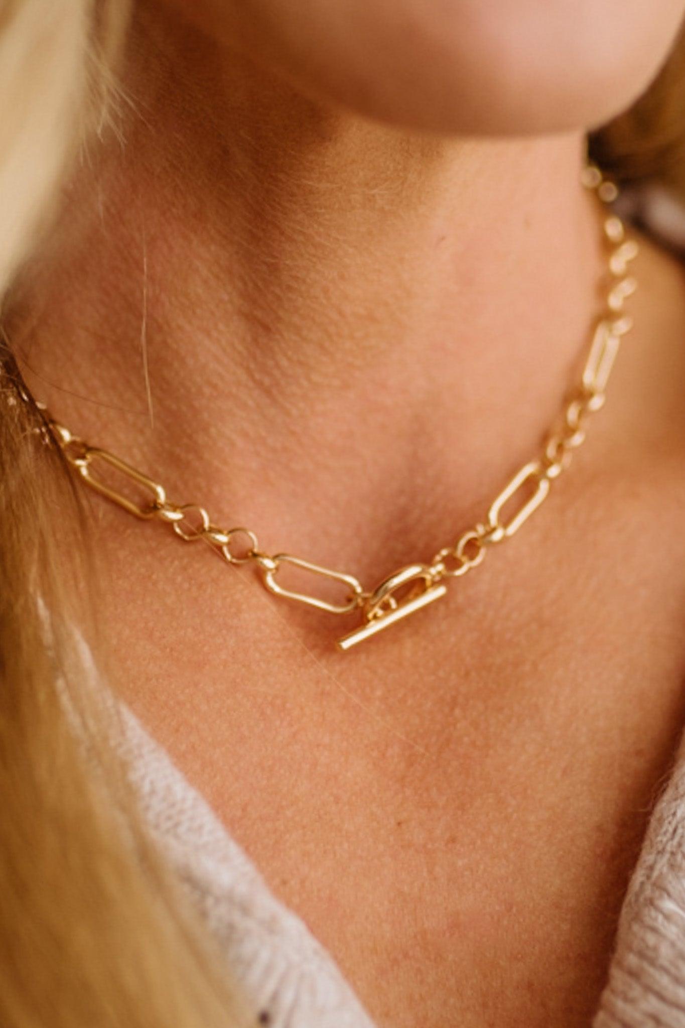 Gold chain necklace on a person's neck