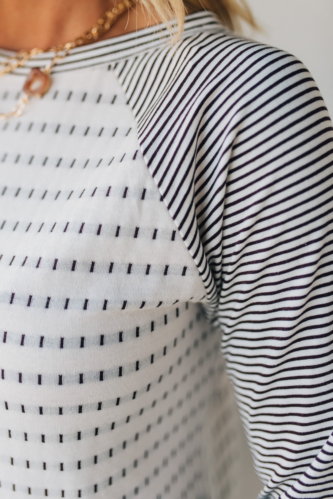 Close-up of a person wearing a black and white striped shirt.
