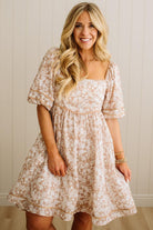 Woman wearing a floral dress with a neutral background