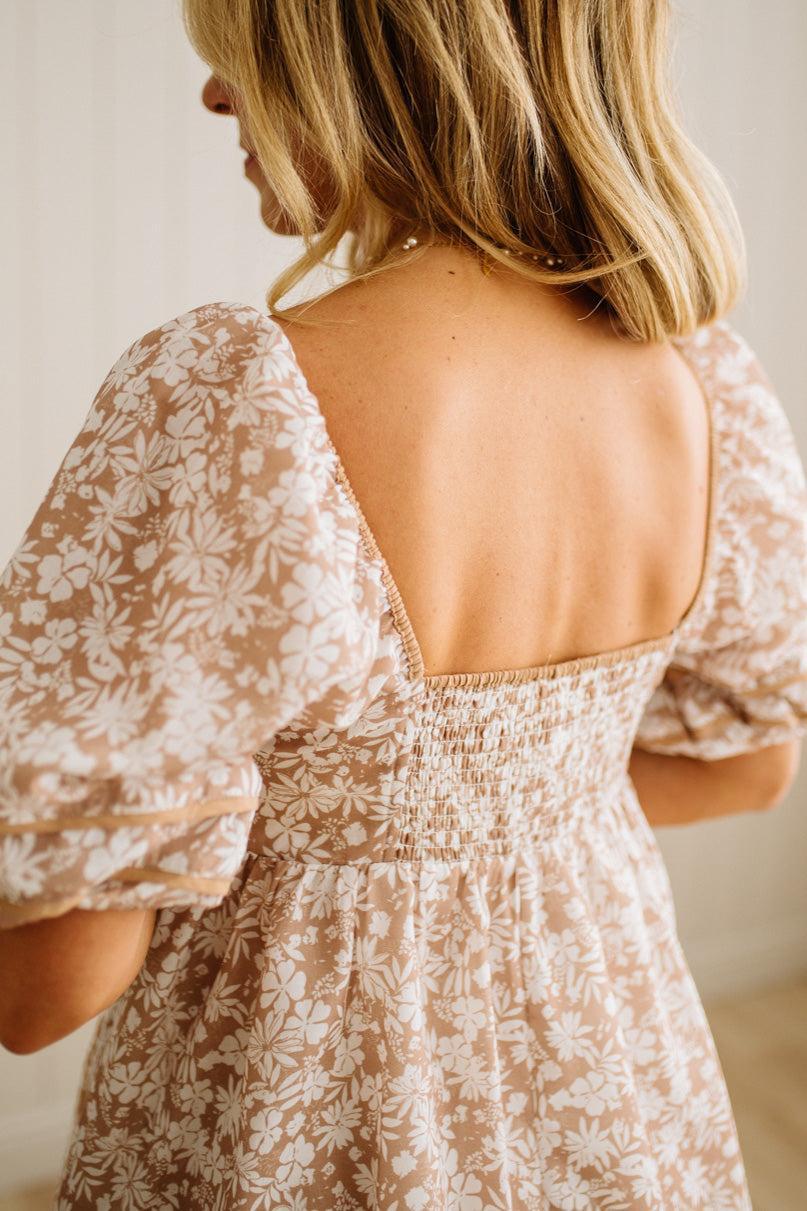 Woman wearing a floral dress with a plain background
