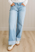 Person wearing light blue jeans with a neutral background