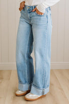 Person wearing light blue jeans with a white background