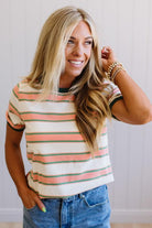 Woman wearing a striped shirt and jeans with a neutral background