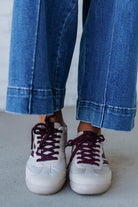 Beige sneakers with wine colored stripes and laces
