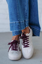 Beige sneakers with wine colored stripes and laces