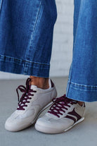 Beige sneakers with wine colored stripes and laces