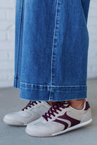 Beige sneakers with wine colored stripes and laces