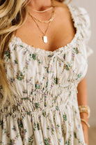 Floral dress with ruffled sleeves and neckline, worn by a person.