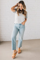 BLONDE WOMAN WEARING A ROUND NECK TOP WITH MICRO STRIPED RAGLAN SHORT SLEEVES, AND DOTTED STRIPE KNIT BODY.