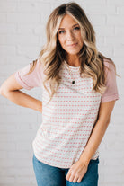 BLONDE WOMAN WEARING A ROUND NECK TOP WITH MICRO STRIPED RAGLAN SHORT SLEEVES, AND DOTTED STRIPE KNIT BODY.