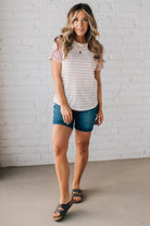 BLONDE WOMAN WEARING A ROUND NECK TOP WITH MICRO STRIPED RAGLAN SHORT SLEEVES, AND DOTTED STRIPE KNIT BODY.