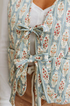 Floral patterned garment with bows on a plain background