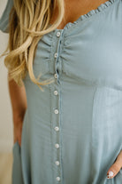 Light blue dress with button details worn by a person