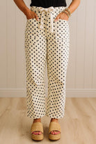Person wearing polka dot pants with a neutral background