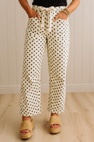 Person wearing polka dot pants with a neutral background