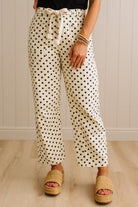 Person wearing polka dot pants with a neutral background