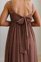 Brown polka dot dress with a bow detail on the back, worn by a person.