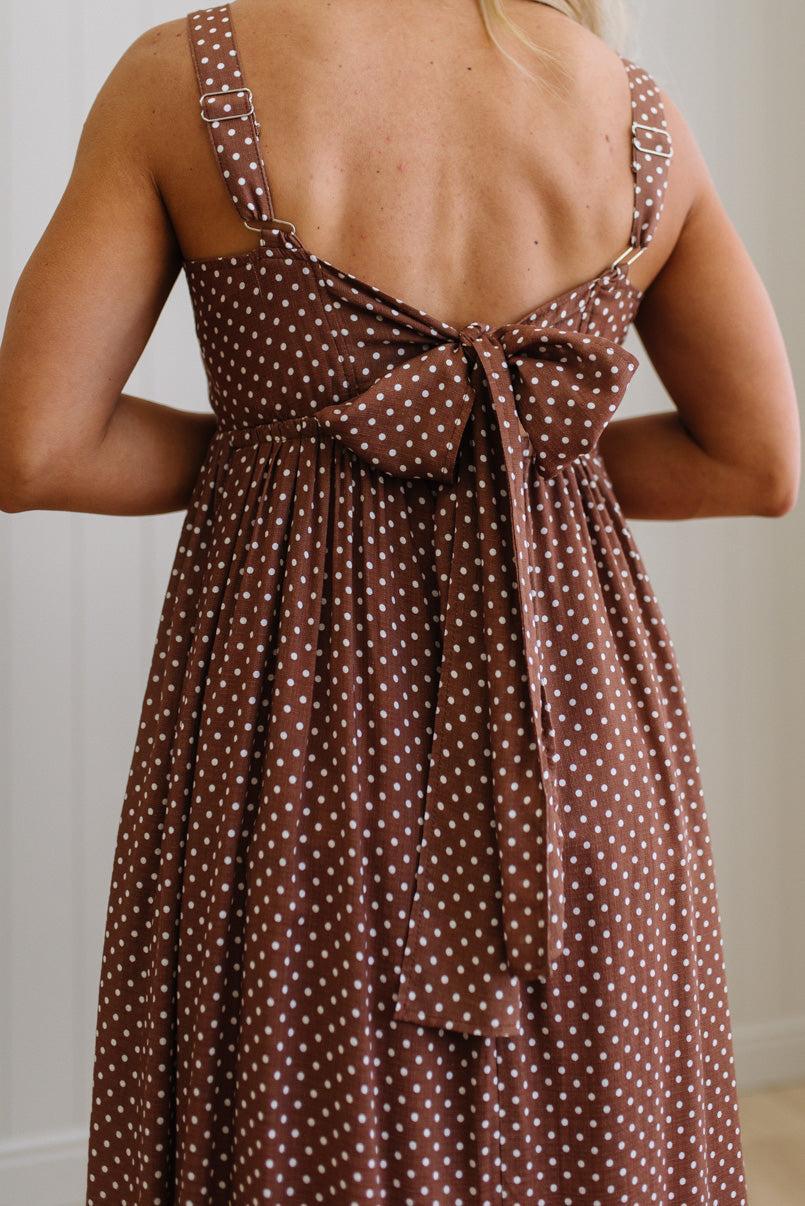 Brown polka dot dress with a bow detail on the back, worn by a person.