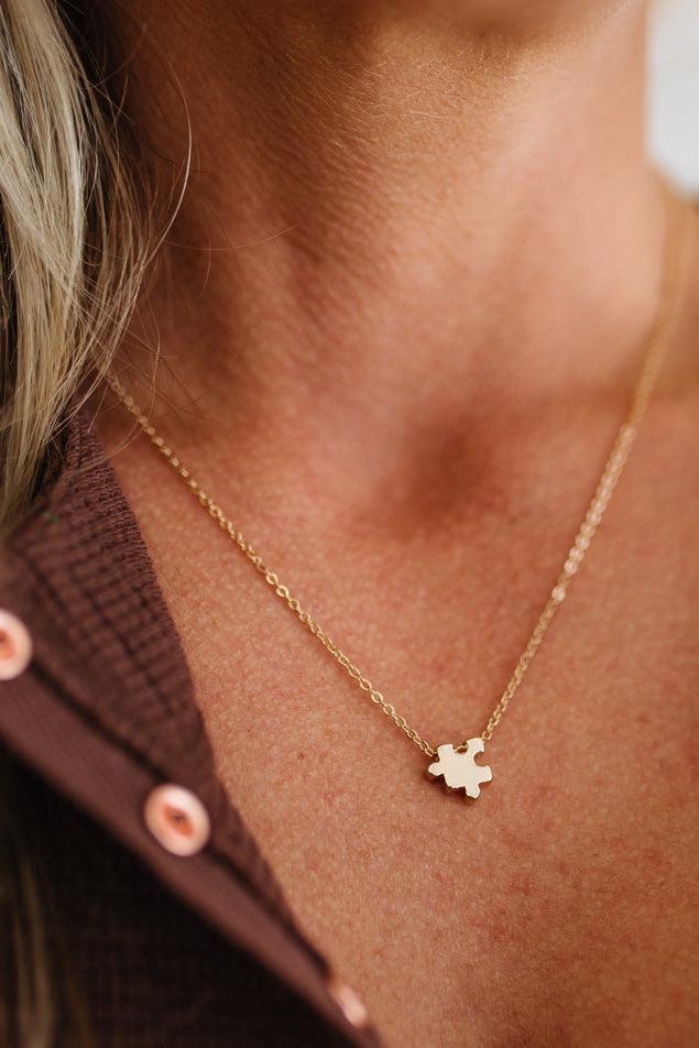 Gold necklace with a small pendant worn by a person