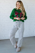 BLONDE WOMAN WEARING CHECKERED PLAID BIG RIBBON CHRISTMAS HOLIDAY LOOSE FIT SWEATER PULL OVER TOP