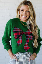 BLONDE WOMAN WEARING CHECKERED PLAID BIG RIBBON CHRISTMAS HOLIDAY LOOSE FIT SWEATER PULL OVER TOP