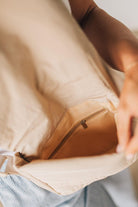 Blonde woman wearing a Foldover Quilted Crossbody bag in stone color.