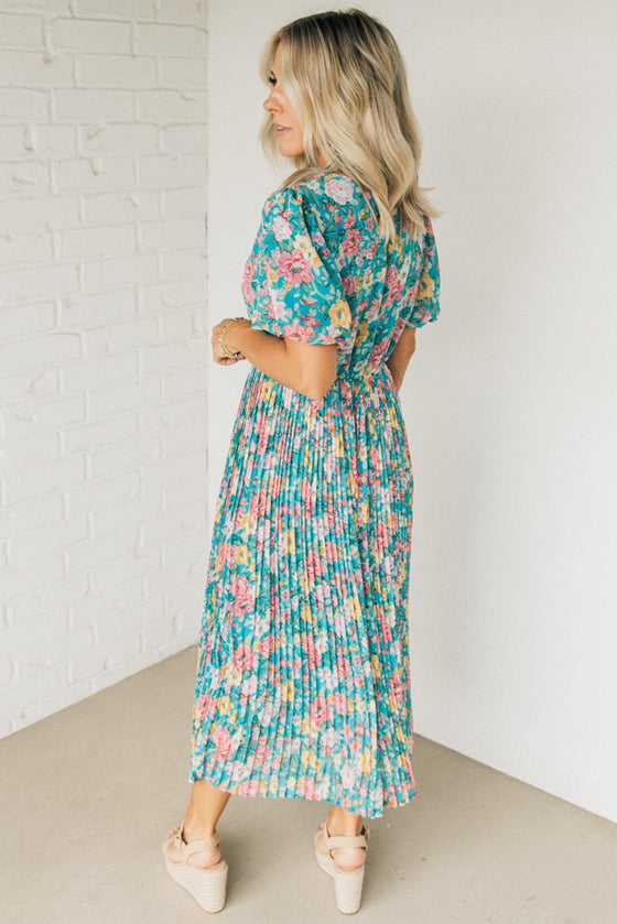 Women wearing a floral midi dress with short puff sleeves and a pleated skirt.