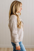 BLONDE WOMAN IN DARK JEANS WEARING A HORSE JACQUARD, STITCH TRIM ACCENT, LONG SLEEVE, CREW NECK PULLOVER SWEATER WITH A HORSE ON THE FRONT, AND WEARING A BIG BELT BUCKLE TOO.
