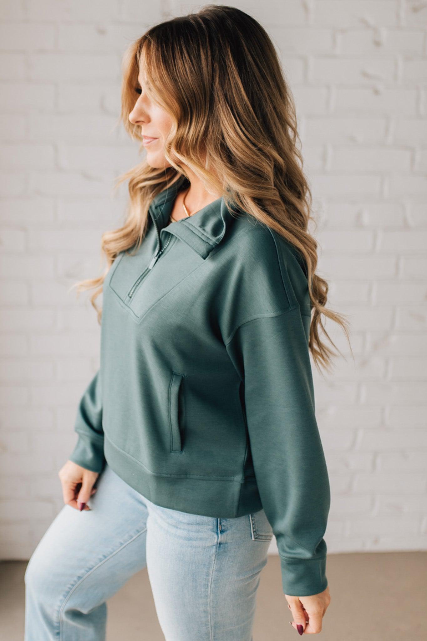 Women modeling a long sleeve, half zip solid colored scuba pullover in forest green