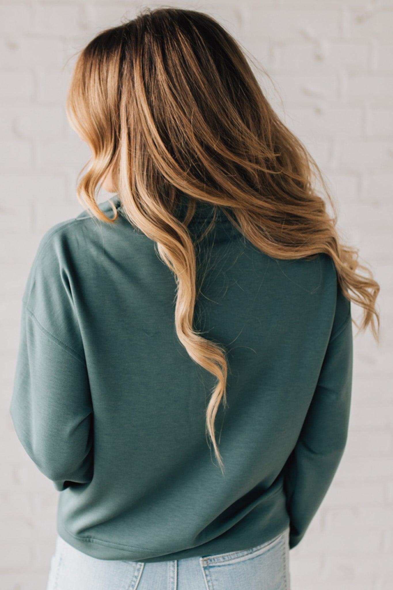 Women modeling a long sleeve, half zip solid colored scuba pullover in forest green