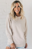 Woman wearing ribbed time sweatshirt with side pockets.