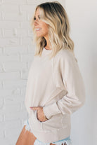 Woman wearing ribbed time sweatshirt with side pockets.