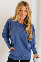 Woman wearing a blue sweater with a plain background